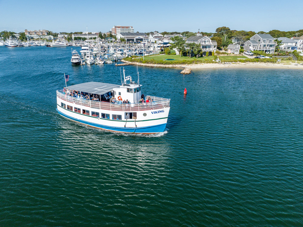 A boat is traveling in the water near houses.