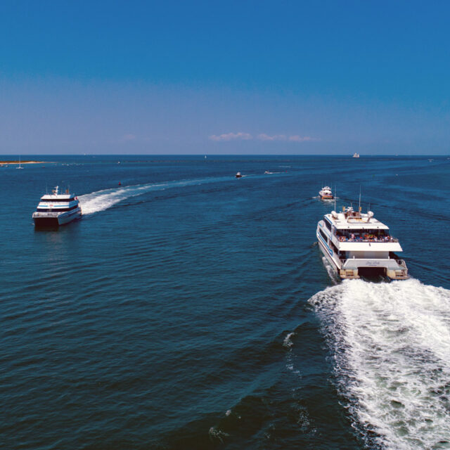 A group of boats traveling in the ocean.