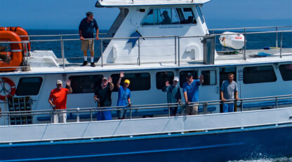 Cape Cod fishing boat on the water with fishermen waving