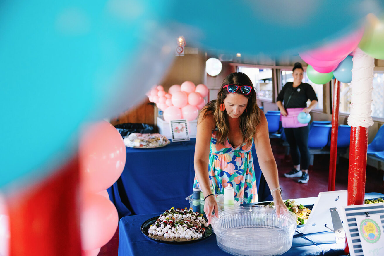 woman in a colorful dress setting up party with balloons