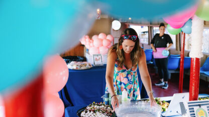 woman in a colorful dress setting up party with balloons