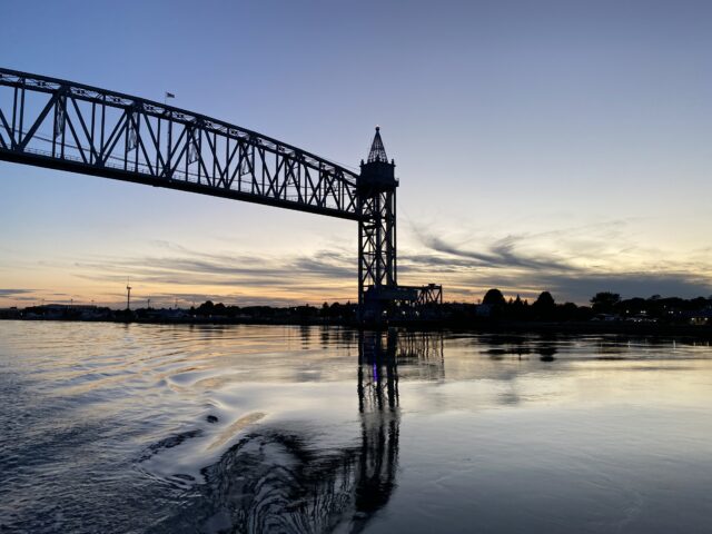 railroad bridge over water at sunset